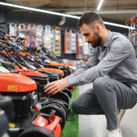 Robotniiduk ja murutraktor kõrvuti koduaias.