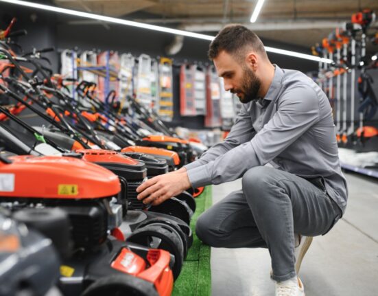 Robotniiduk ja murutraktor kõrvuti koduaias.